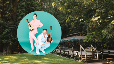 Mike Marshall and Caterina Lichtenberg pose wearing pastel-colored suits. Background image is of the Henry Miller Library.