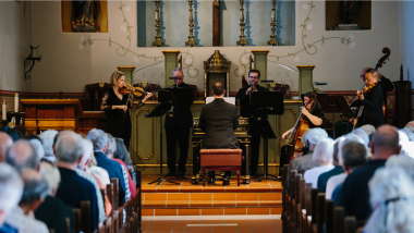 A small chamber ensemble plays on an altar.