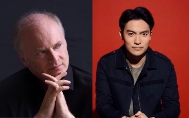 Gianandrea Noseda (left) poses with his hands on his chin and Ray Chen (right) poses looking straight ahead in front of a red background.