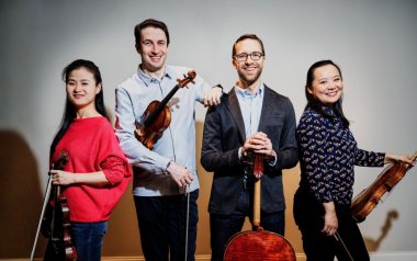 The four members of the Rosamunde String Quartet pose together with their instruments.