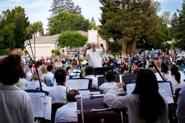 conducting an orchestra, outdoors