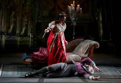 Tosca, the knife still in her hand, looms over the dying Scarpia 