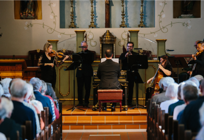 A small chamber ensemble plays on an altar.