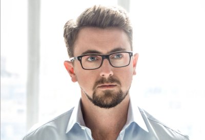 A portrait of a man with a beard and glasses.