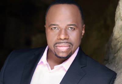 A headshot of man with a tuxedo who is looking directly at the camera. 