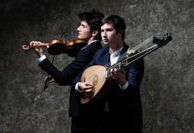 Portrait of Théotime Langlois de Swarte and Thomas Dunford holding their respective instrument in front of a gray back drop